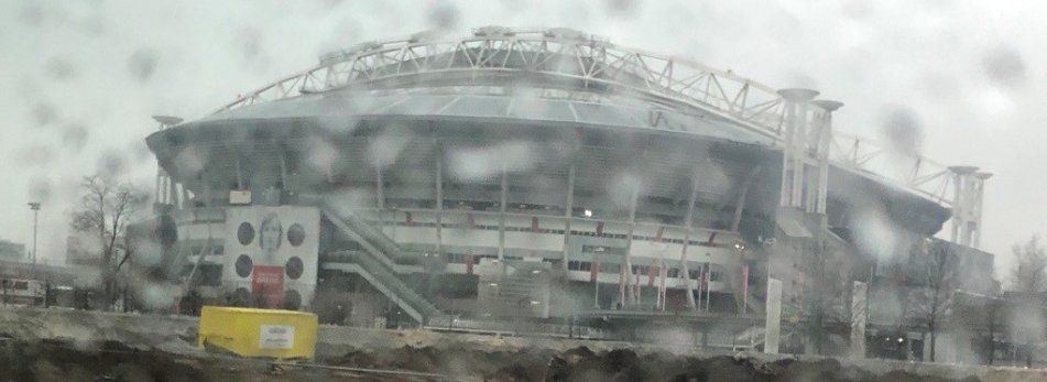 The Johan Cruijff Arena rises up out of the reclaimed earth, it looms over everything, even when its backdrop is a permanent shroud of grey